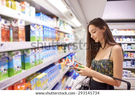 young woman shopping for fruits and vegetables in produce department of a grocery store supermarket
