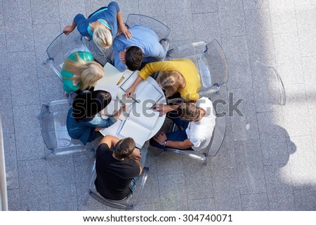 top view,  group of students together  at school table working homework and have fun