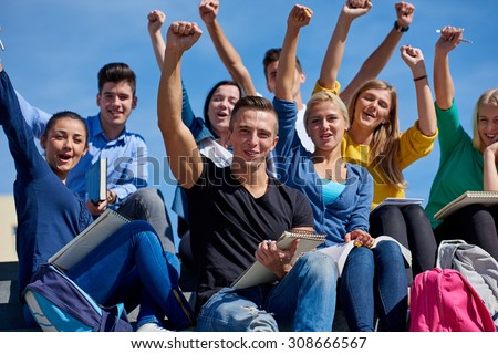 Group portrait  of happy  students outside in front of school sitting on steps have fun