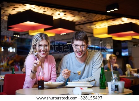 couple having lunch break in shopping mall food corner