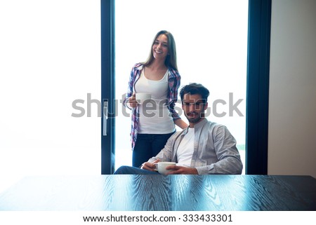 relaxet young couple drink first morning coffee  over big bright window in moder home villa interior