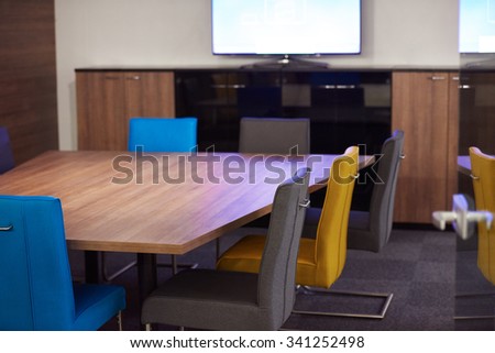 meeting office room with white modern table and orange chairs with glass wall