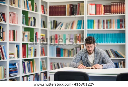 Portrait of happy student while reading book in school library. Study lessons for  exam. Hard worker and persistence concept.