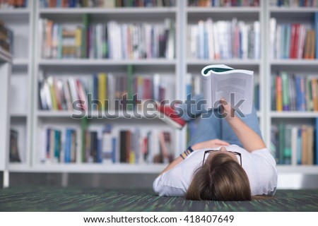 smart looking famale student  in library reading book