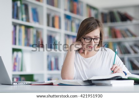 female student study in  library using laptop and searching for informations on internet