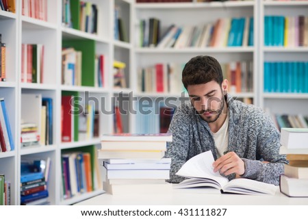 Portrait of happy student while reading book in school library. Study lessons for  exam. Hard worker and persistance concept.