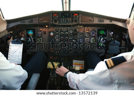 two pilots in cockpit of plane during mountain-flight