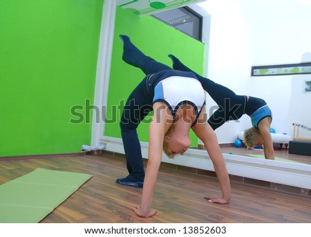 women in a fitness centerpretty girl practicing yoga in fitness club with green wall in background