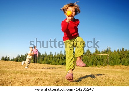 young girl with apple running in field