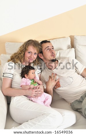 indoor portrait with happy young family and  cute little babby