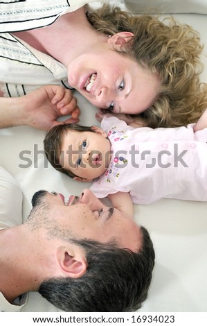 indoor portrait with happy young family and  cute little babbybeautiful blonde young mother and cute baby