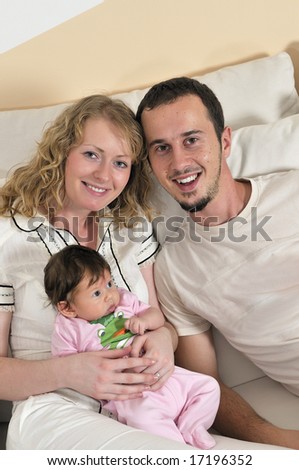indoor portrait with happy young family and  cute little baby