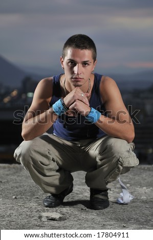 urban style boy portrait in crouch pose