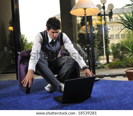 Happy young man sitting relaxed working on laptop computer