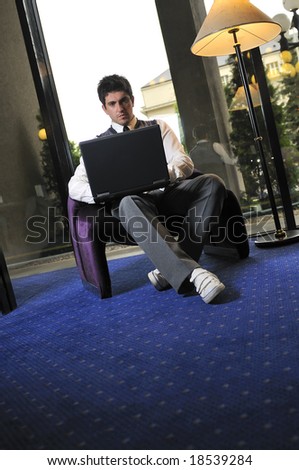 Happy young man sitting relaxed working on laptop computer
