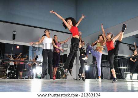 gorup of girls in fitness studio jumping in air
