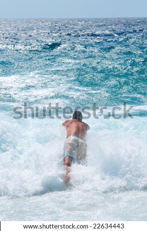 happy man jump in sea with big waves