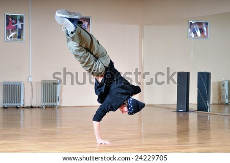 young man performing break dance in dance studio