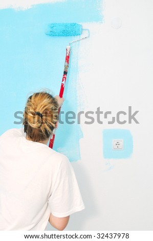 young happy couple painting their new home interior