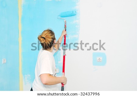 young happy couple painting their new home interior