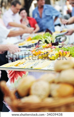 people choosing food from table on catering and buffet party on business seminar conference or wedding