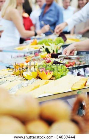 people choosing food from table on catering and buffet party on business seminar conference or wedding