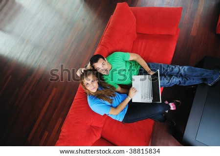 happy young couple have fun and relax at comfort bright apartment and work on laptop computerhappy young couple have fun and relax at comfort bright apartment and work on laptop computer