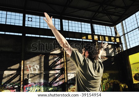 happy young man posing outdoor in urban environment with graffiti in background