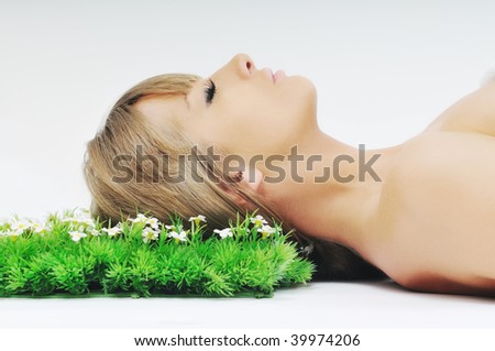 beautiful blonde woman face isolated on white with small green peace of grass
