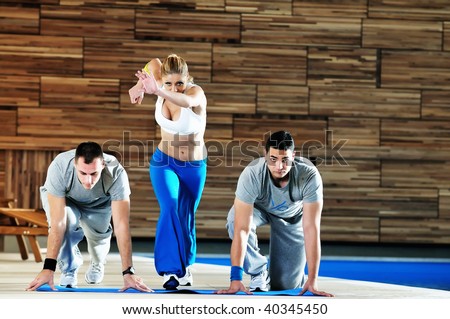 fitness personal trainer on fitness classes supporting group of people and working out together in team