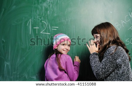 happy child in school classroom solving math problem and have friend to help find solution