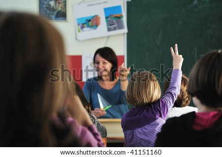 happy young teacher woman at elementary school teaching and giving leassons to group of young smart children