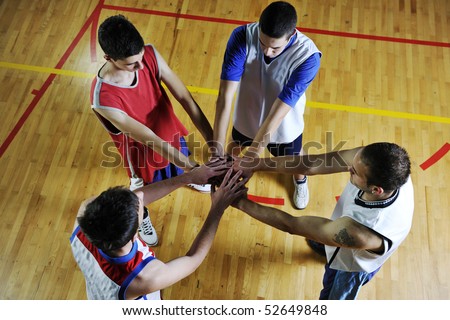 basketball game players holding together as team representing team spirit