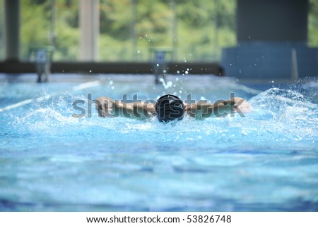 young healthy man with muscular body swims in swimming pool and representing healthy and recreation concept