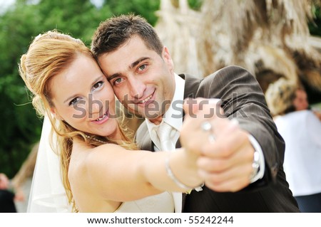 stock photo : happy young and beautiful bride and groom at wedding party  outdoor