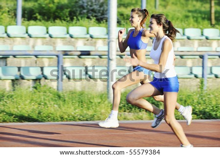 young girl morning run and competition on athletic race track