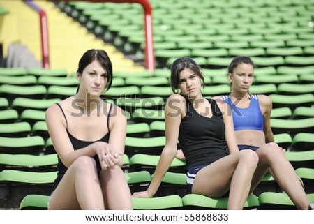 happy young group of girls relax and have break at athletics stadium