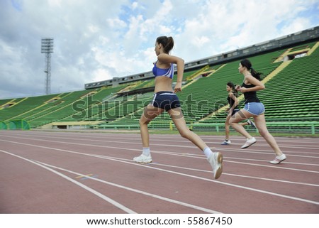 three athlete woman running on athletics race track on soccer stadium and representing competition concept in sport