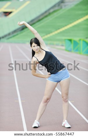 happy young woman streching at athletics stadium and relax