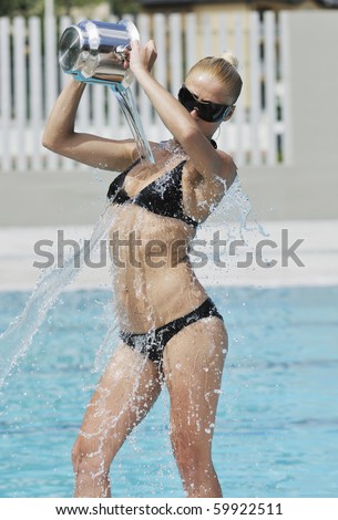 young beautiful woman relax and have fun with splashing water at hotel swimming pool young beautiful woman relax and have fun with splashing water at hotel swimming pool