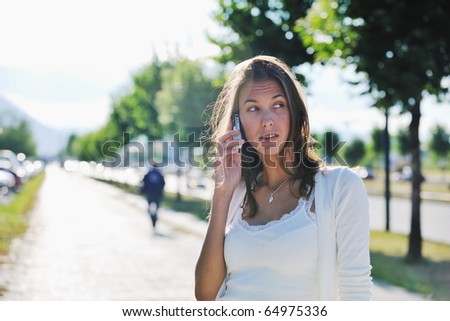 beautiful fit young woman talk by cellphone in city at street on sunny day