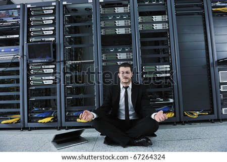 young handsome business man in black suit and tie practice yoga and relax at network server room while representing stres control concept
