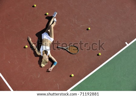 young fit woman play tennis outdoor on orange tennis field at early morning