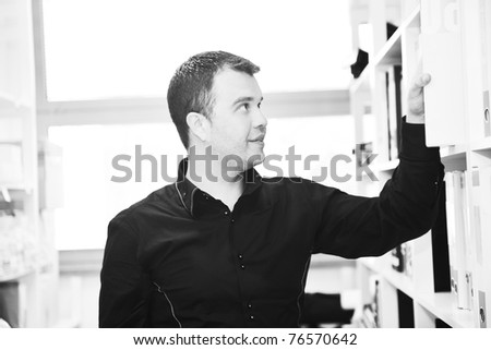 business man male adult in archive library looking and searching for book and documents representing storage and education concept