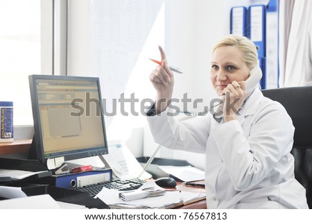 pharmacy worker talking by phone and typing and computer keyboard