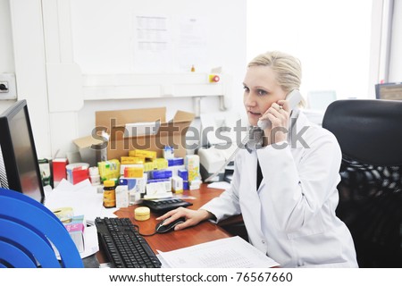 pharmacy worker talking by phone and typing and computer keyboard