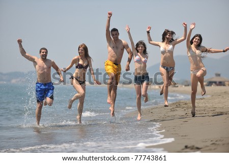 happy people group have fun  run and jump  on beach beautiful sand  beach