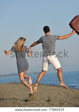couple on beach with travel bag representing freedom and funny honeymoon concept