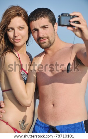 happy young couple in love taking amateur  self portrait photos on beach