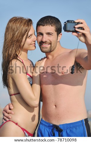 happy young couple in love taking amateur  self portrait photos on beach